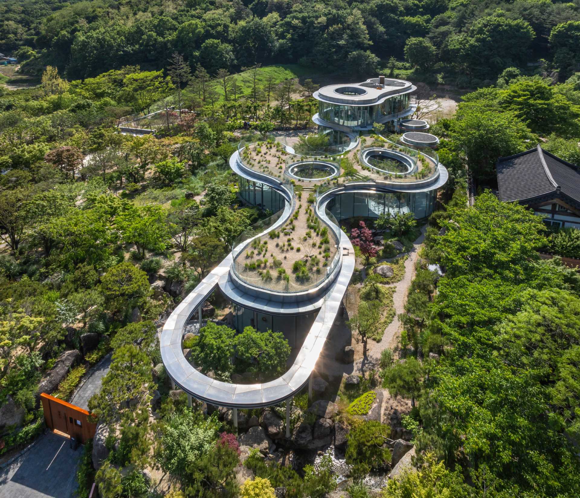 A modern cafe in South Korea, with social spaces and a green roof, was inspired by a walk in the forest.