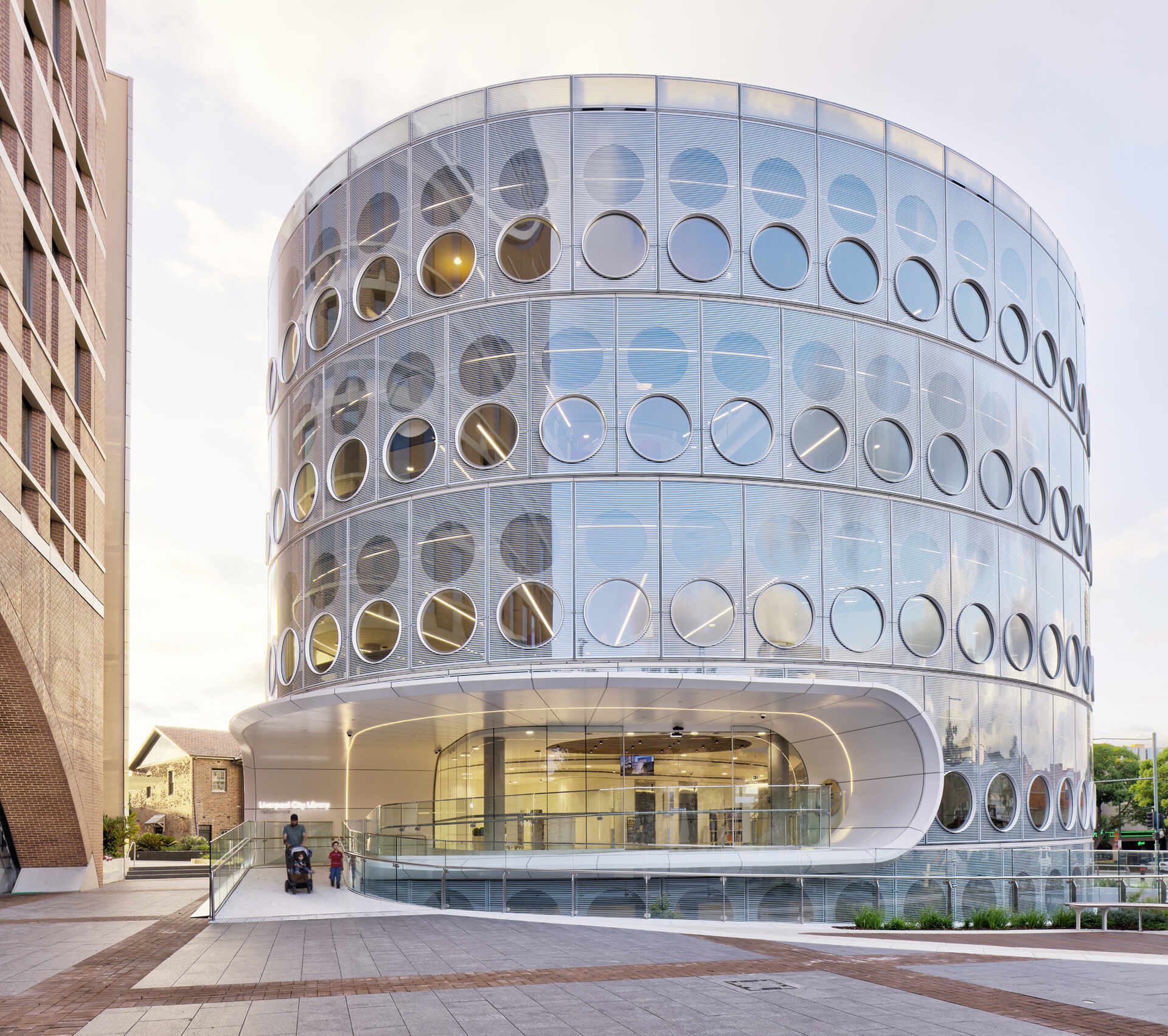 A modern library with a round design, whose exterior facade is covered in matching round windows.