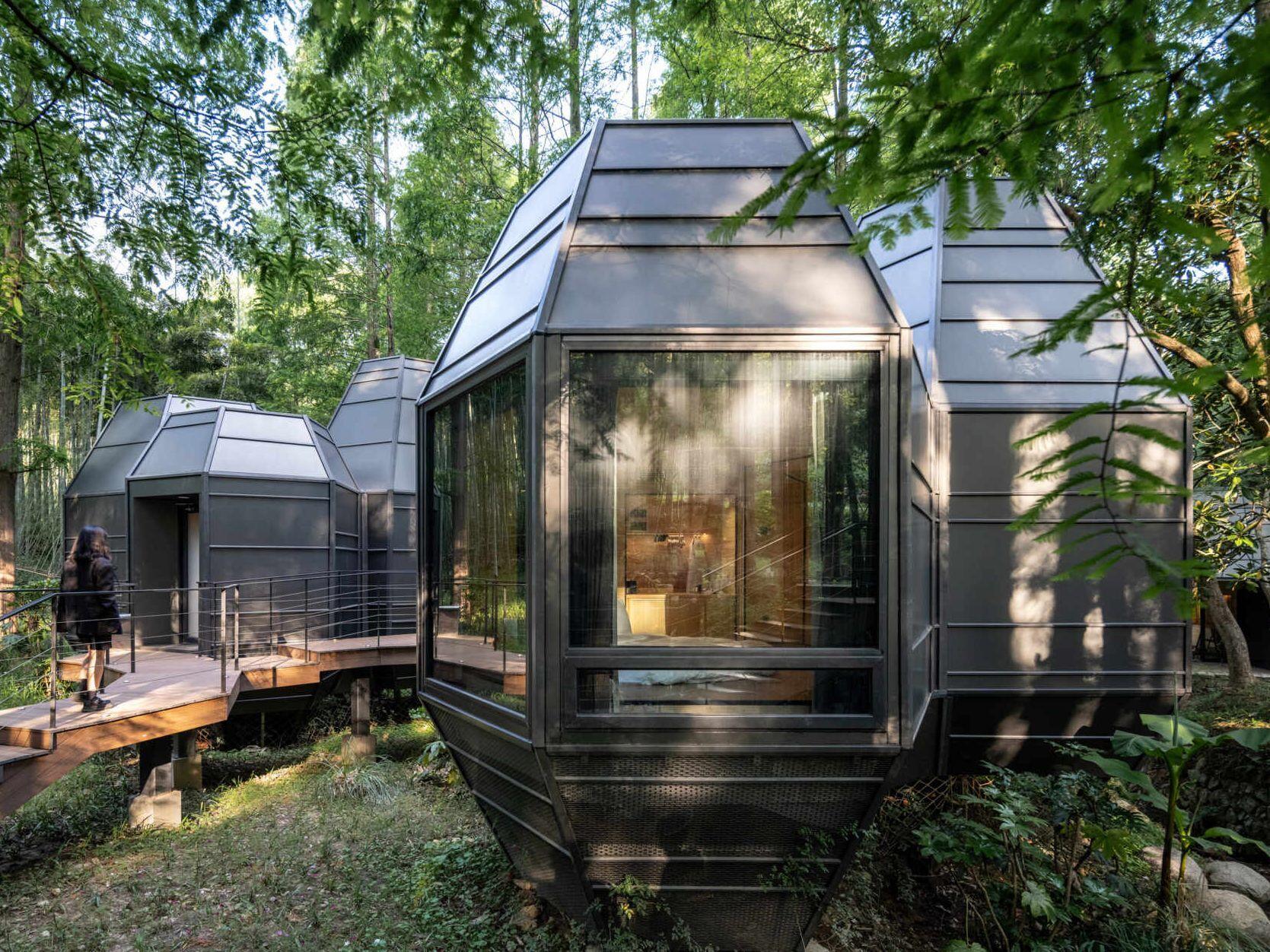 Lightweight and modular, these cabins take cues from pinecones and tree forms. Elevated design preserves the forest floor, while angled rooflines echo the grove’s vertical rhythm.