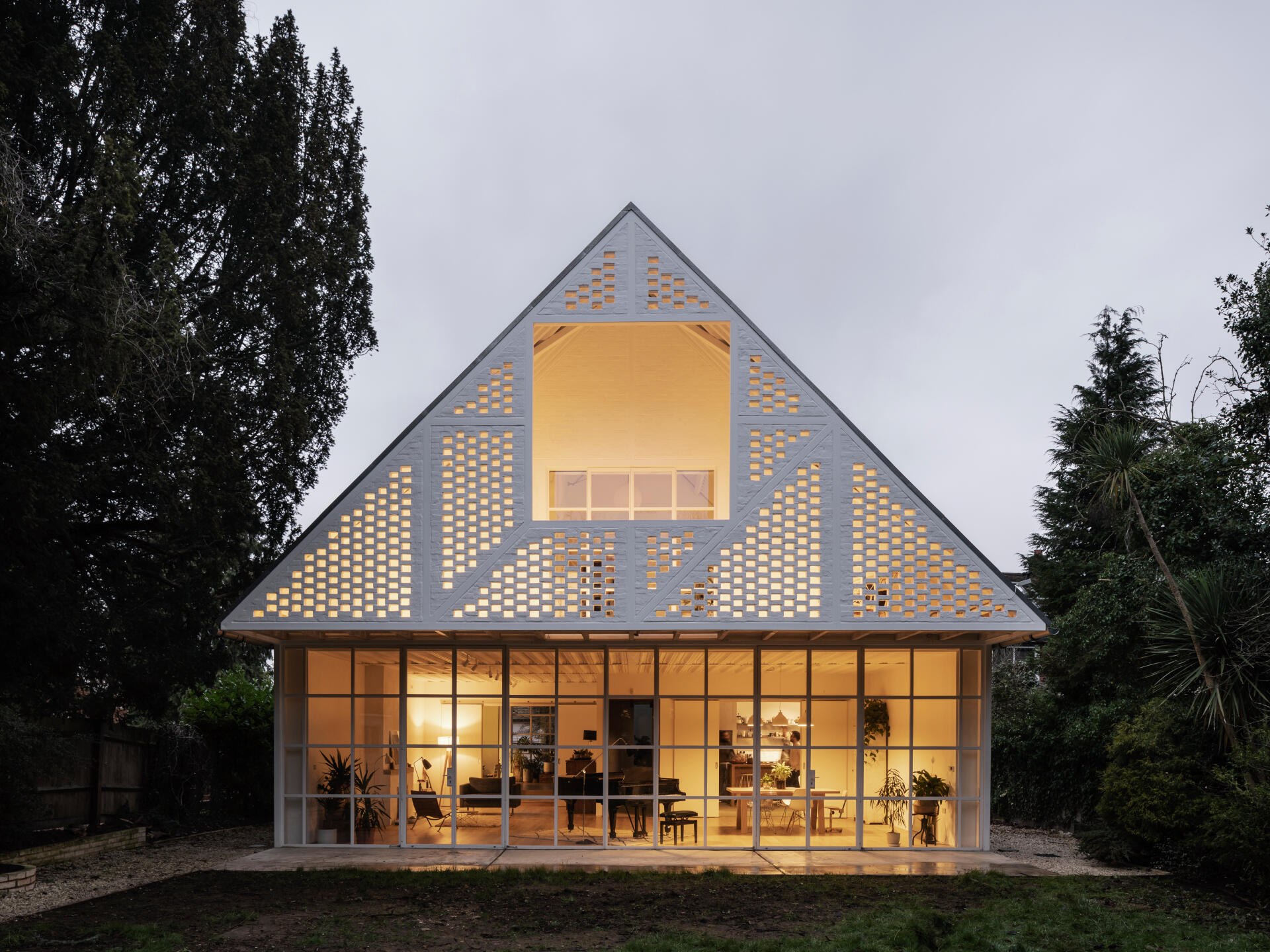 With its pitched roof, steel exoskeleton, and slurried brick infill, this London home borrows from suburban mock-Tudor while turning the style completely on its head.