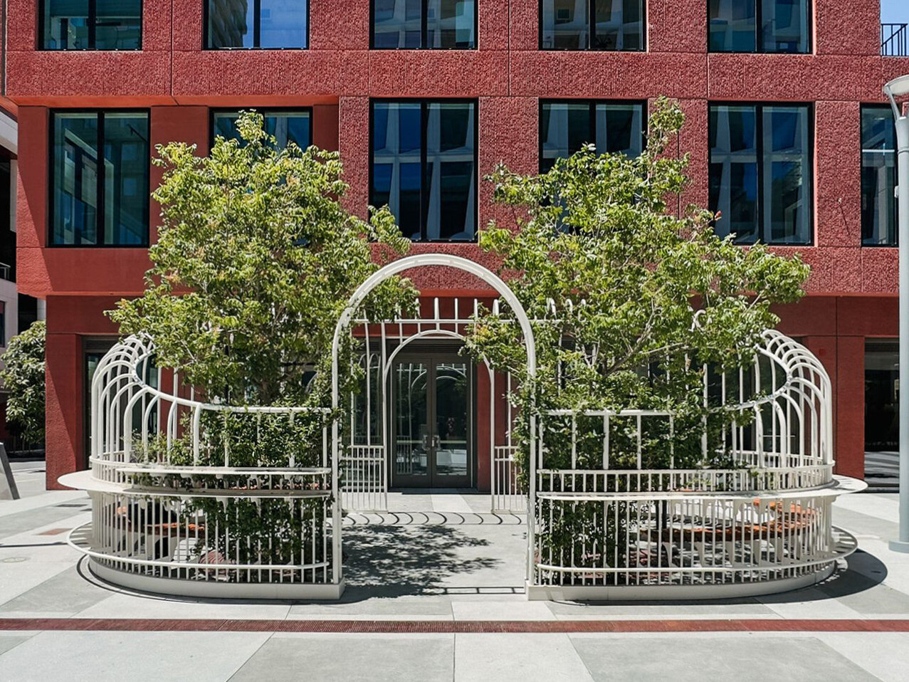 A serene urban pavilion in San Francisco’s Mission Rock, The Garden Party by Min Design reinterprets the Victorian greenhouse as a light-filled public space. With its curving form, custom detailing, and living canopy of integrated trees, this open-air installation invites pedestrians to pause, connect, and enjoy a moment of calm in the city.