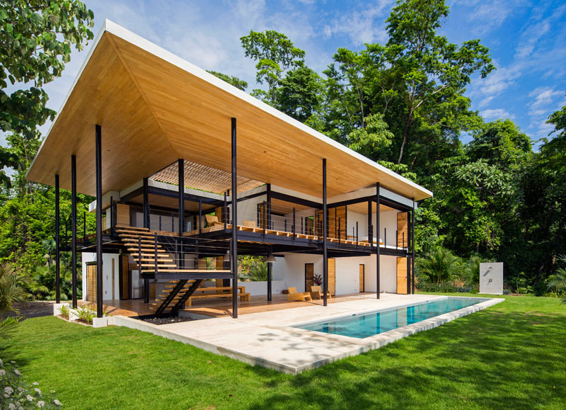 This modern home unfolds through interwoven terraces that step and layer across multiple levels, framing views of both treetops and ocean horizons, while movable wood walls fold away, creating open living spaces.