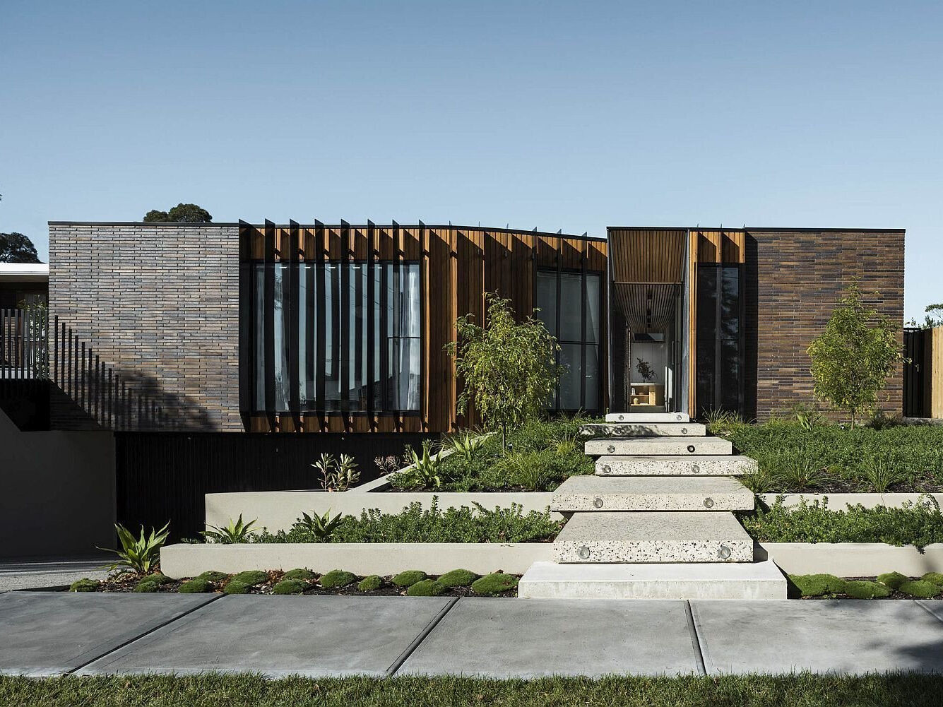 At first glance, the elongated brown brick defines the home’s character. This material, chosen for its ties to the working-class history of the area, wraps the exterior and continues inside, creating rhythm and texture in unexpected places like the entryway. 