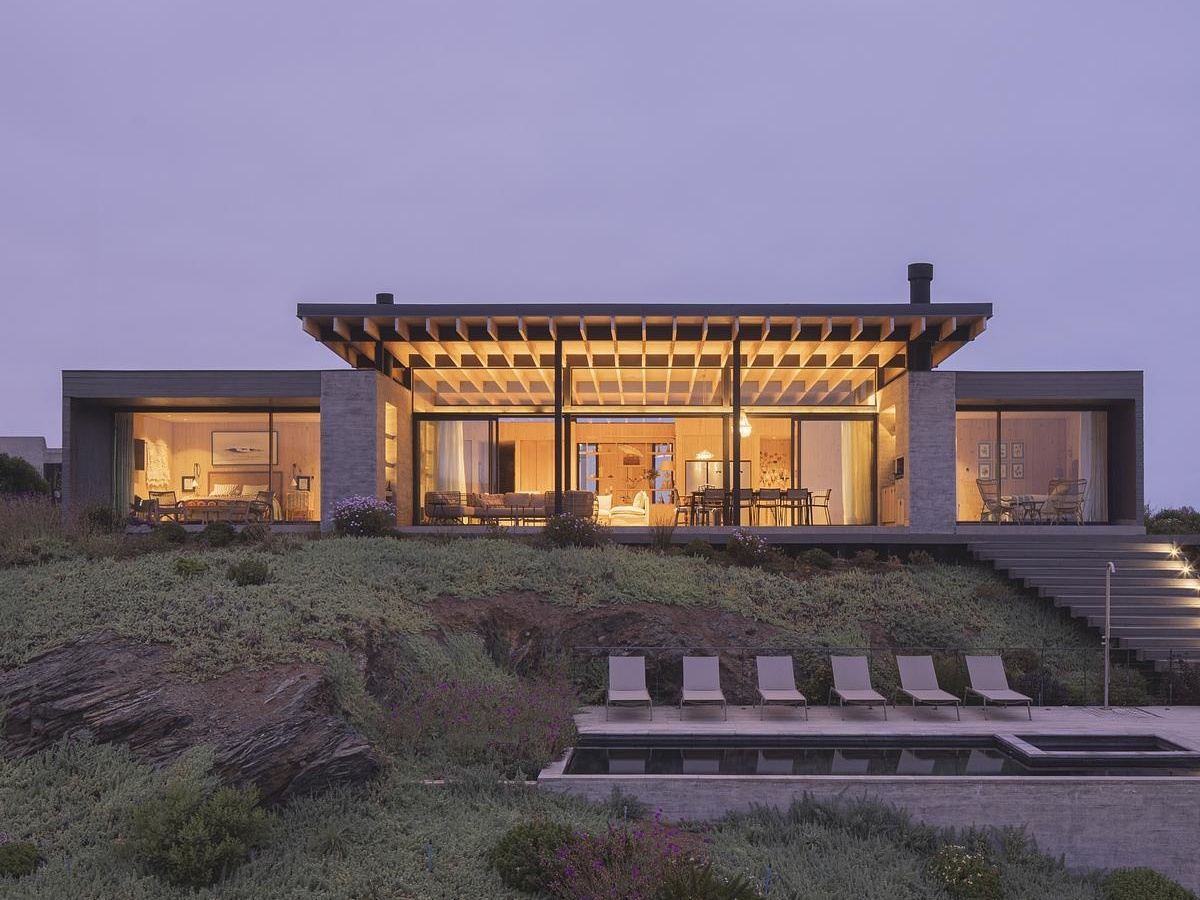 A coastal home in northern Chile designed with four wooden volumes and ocean-facing living spaces.