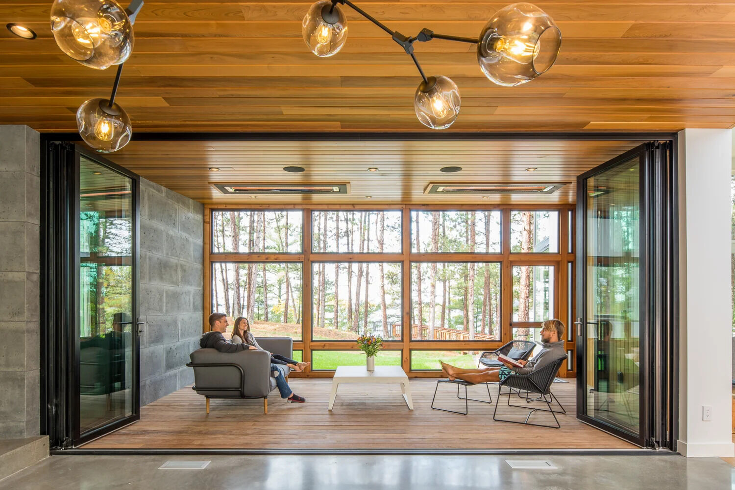 A glass core creates an abundance of light and shows off the lake views and becomes the dining room. The glass walls also separate the large dining area from a enclosed porch. When needed the glass wall can be opened to expose the porch and increase the size of the interior space.