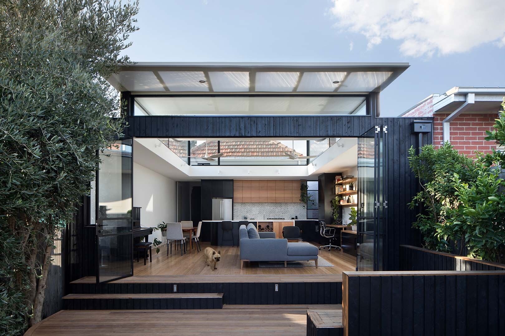 This terrace house opens to the backyard with a timber deck, built-in seating and glass doors that bring the garden directly into daily life.