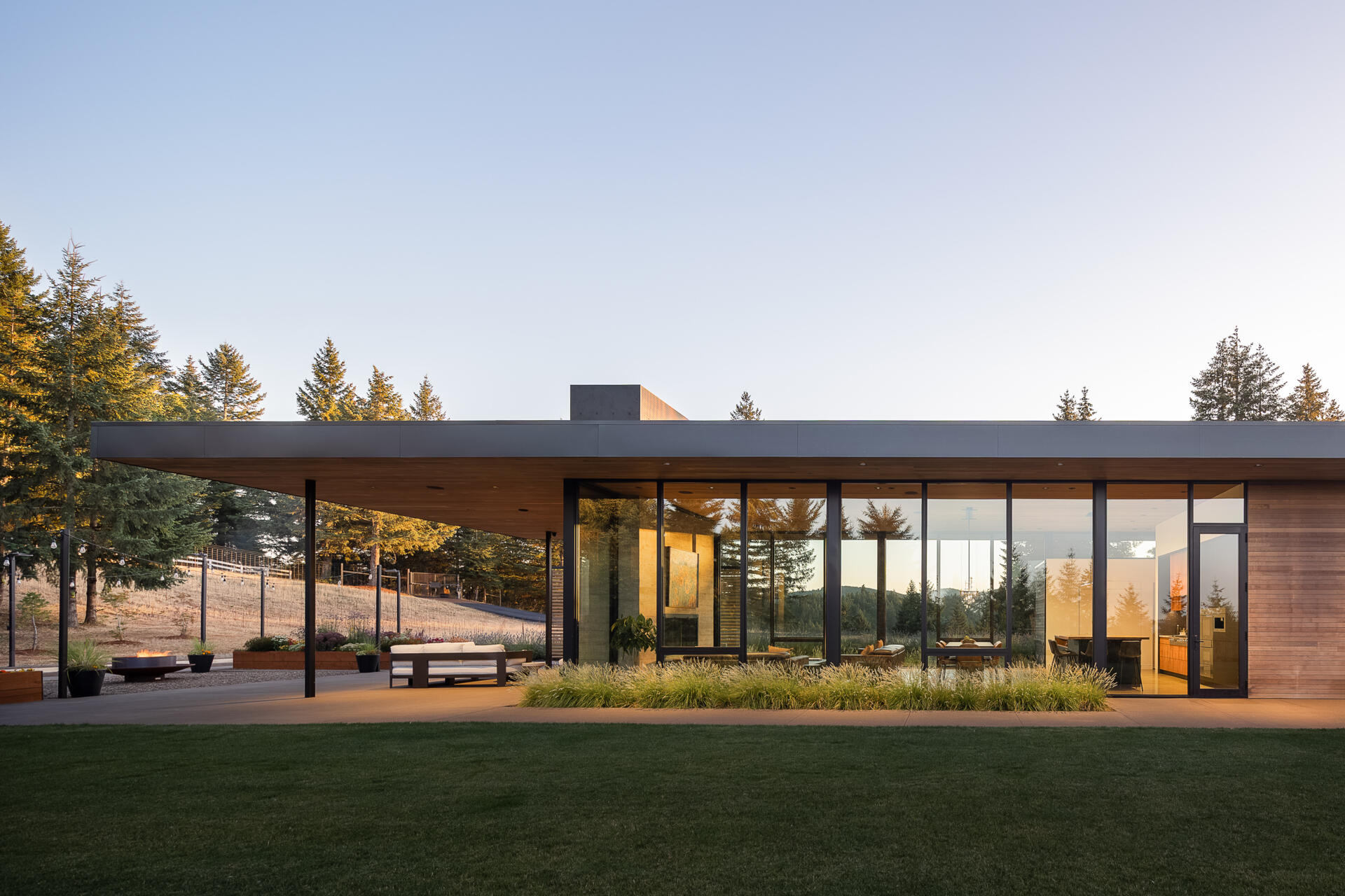 A quiet, cedar clad vineyard home emerges from the evergreens, designed with simple forms and warm minimalism that shape every room.