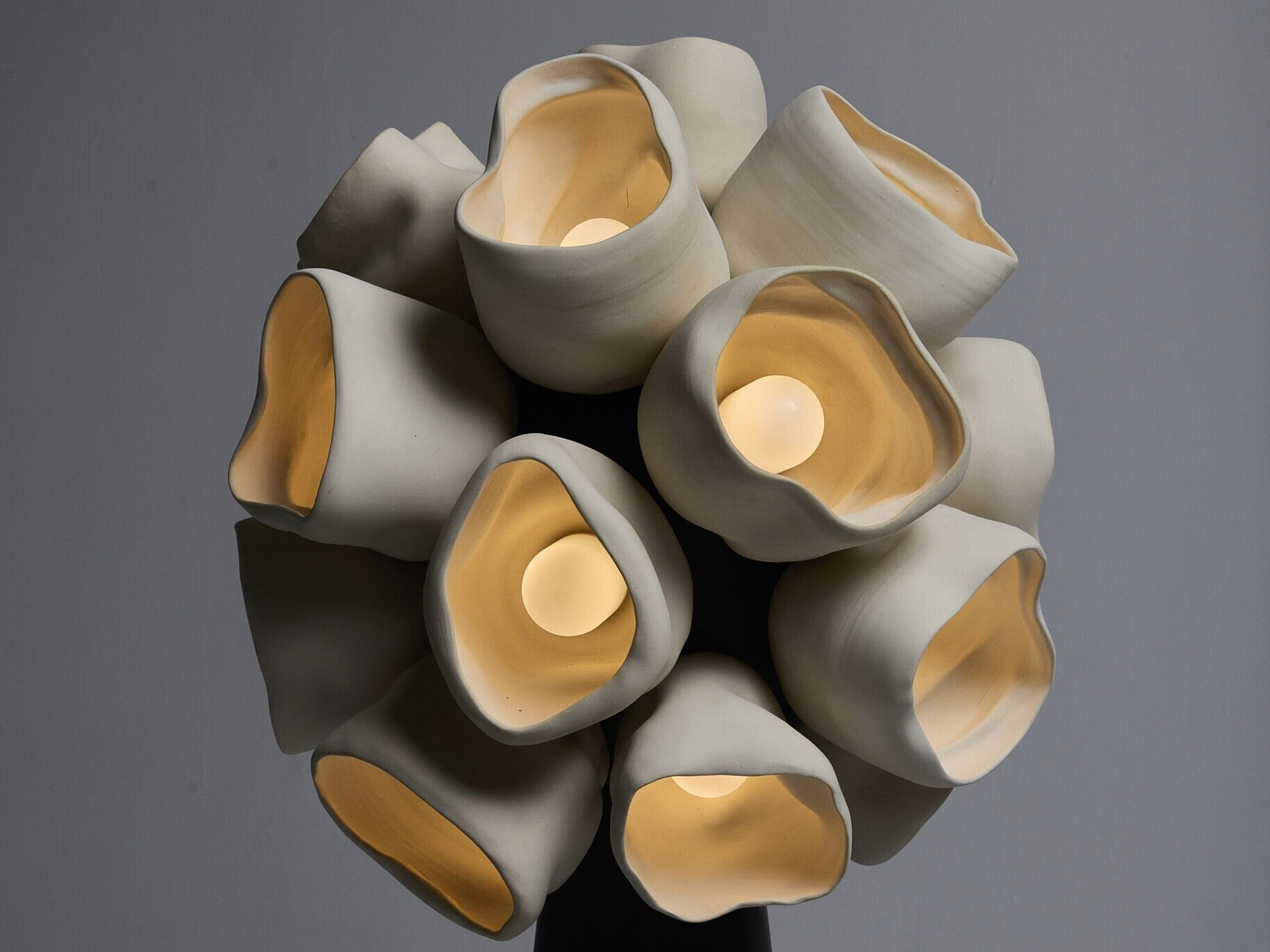 A sculptural lighting collection inspired by cup fungi, Vessels by Nader Gammas blends handmade ceramic craft with soft organic forms, creating glow filled pieces that feel alive within a space.