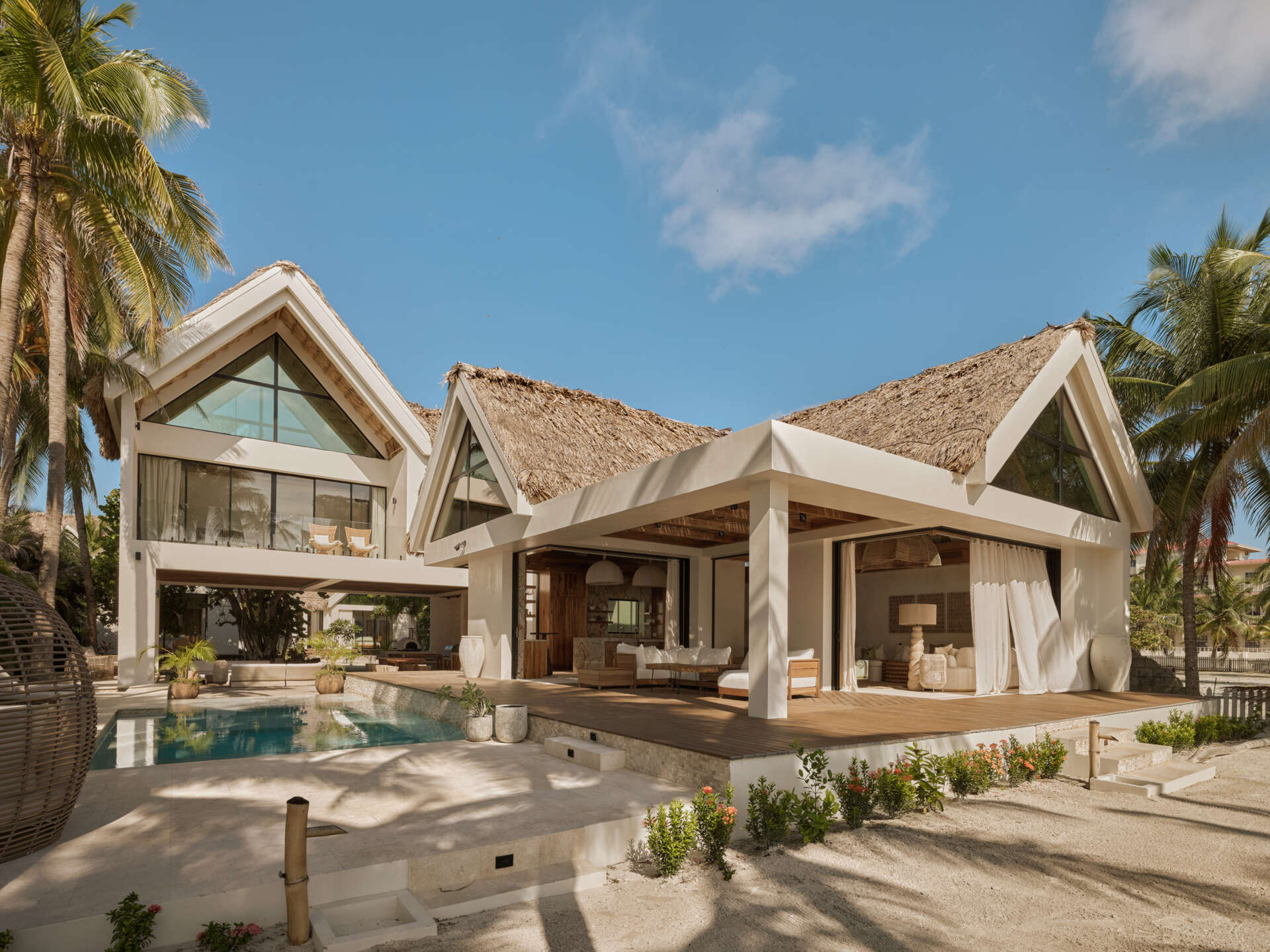 A concrete coastal compound designed to withstand the elements, softened with native woods, palm fronds, and handmade details that connect the home to its island setting.