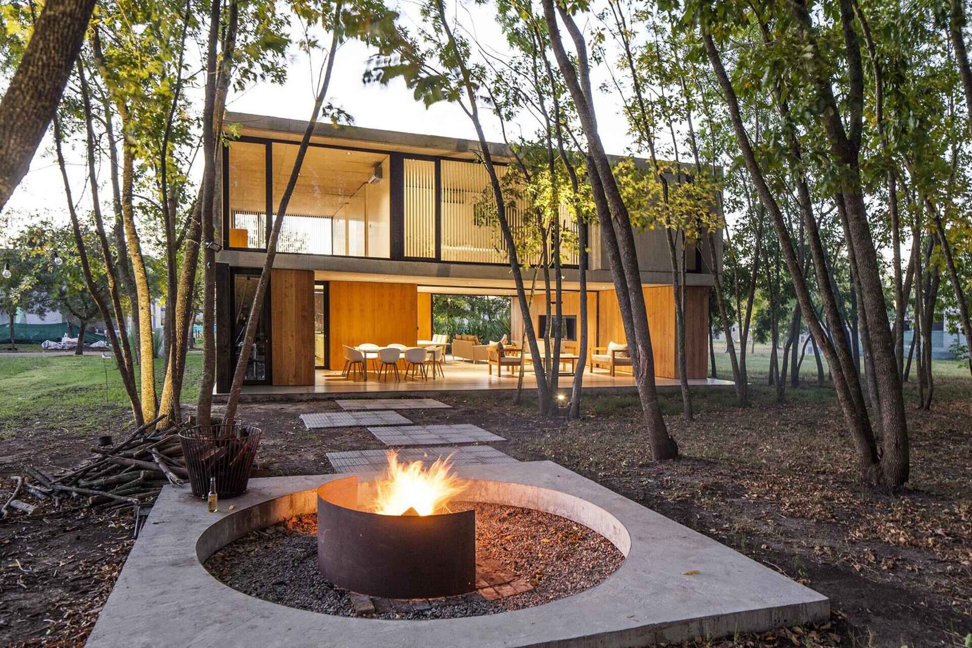 A modern family home in Argentina, designed to sit quietly within an existing ash forest and open toward the surrounding trees.