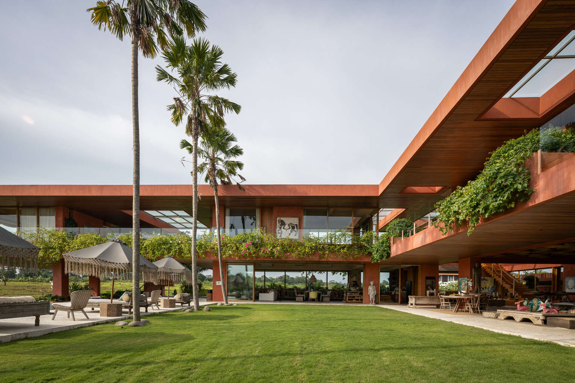 Terracotta-toned concrete, raw geometry, and warm wood define this brutalist house designed to frame art rather than compete with it.