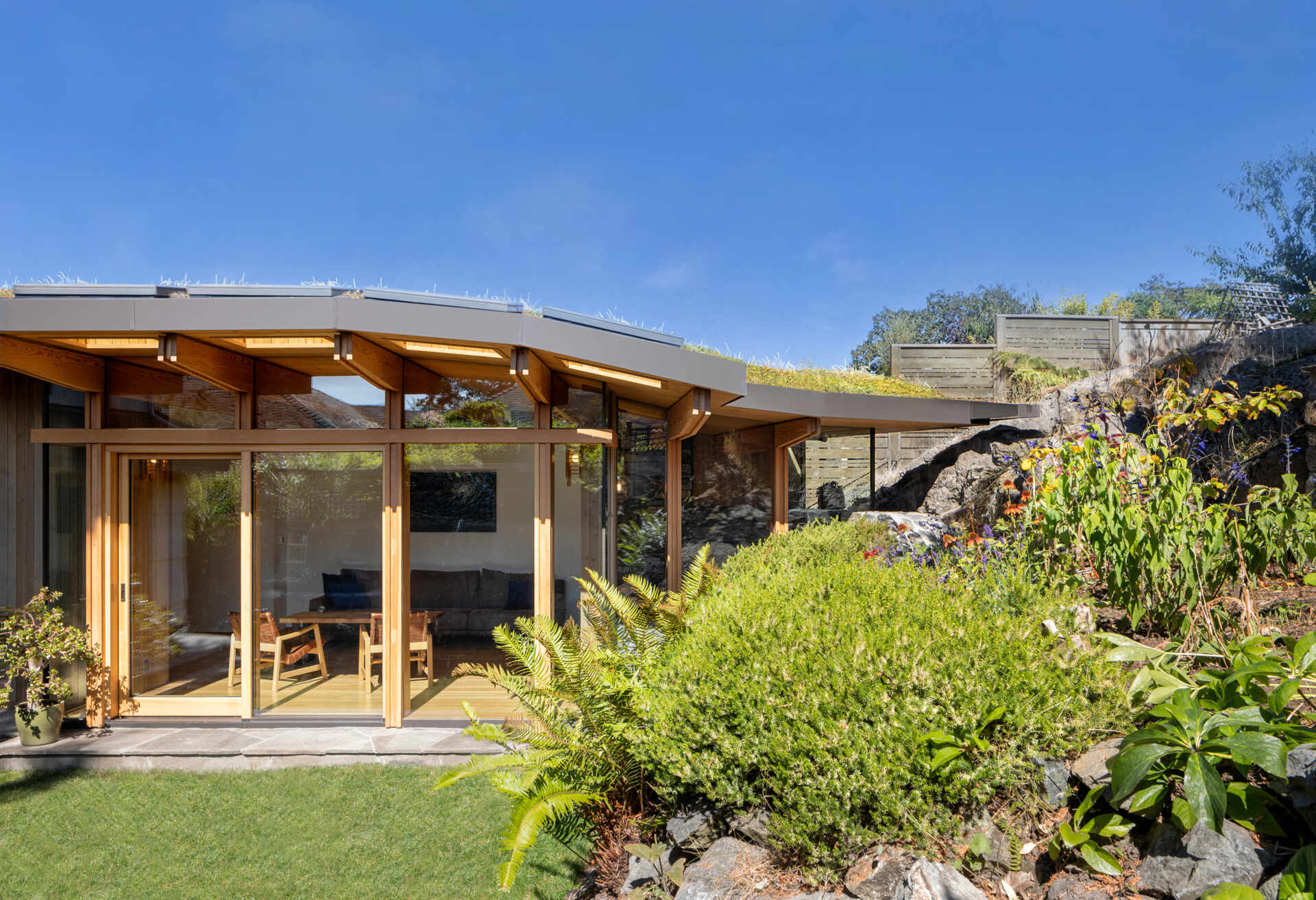 This addition uses a subtractive approach, carving into the rock to create a foothold and reshaping stone from the site into a curving structural wall.