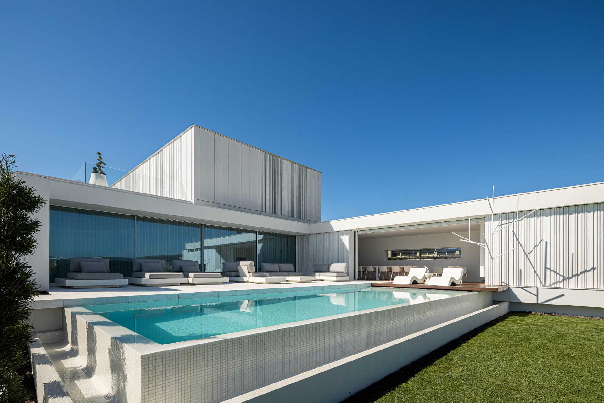 A modern home features an exterior of white concrete with textured accent walls.
