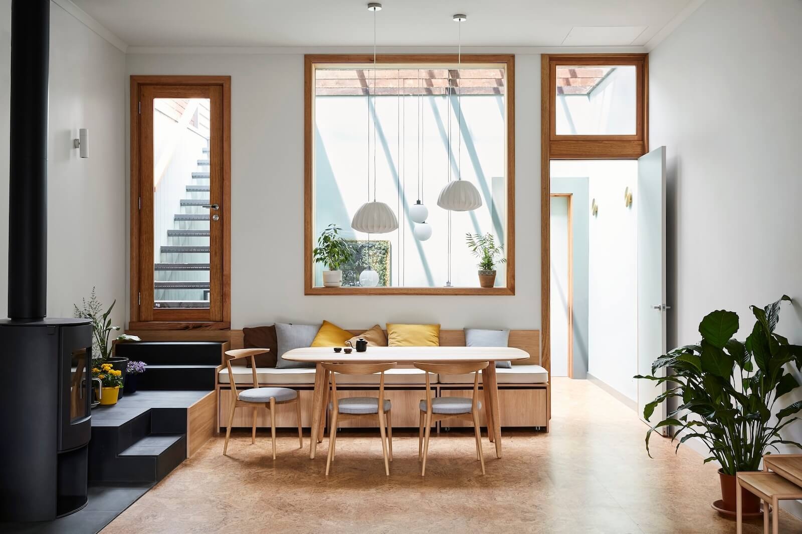 Built-in bench seating in the dining area leads directly to a sunlit rooftop deck.