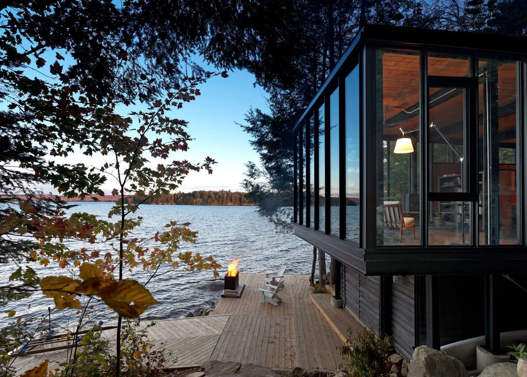 A modern boathouse on Kawagama Lake designed to sit quietly at the water’s edge, combining boat storage with a compact living space above.