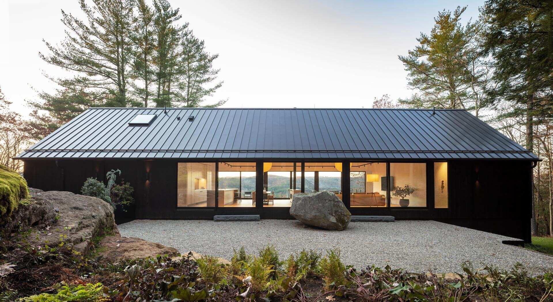 A modern home in Cornwall, Connecticut, built directly on a dramatic rock ledge. Inspired by local barns and the historic West Cornwall Covered Bridge, this forest retreat blends charred wood siding with contemporary design.