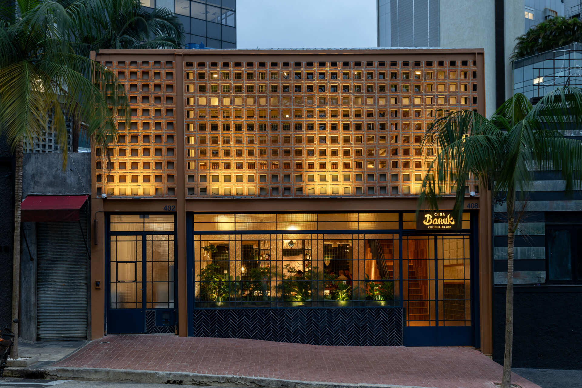 Casa Baruk’s façade combines a terracotta steel frame, blue ironwork, and a ceramic mashrabiya-inspired screen that filters light and creates privacy while maintaining a visual connection with the street.