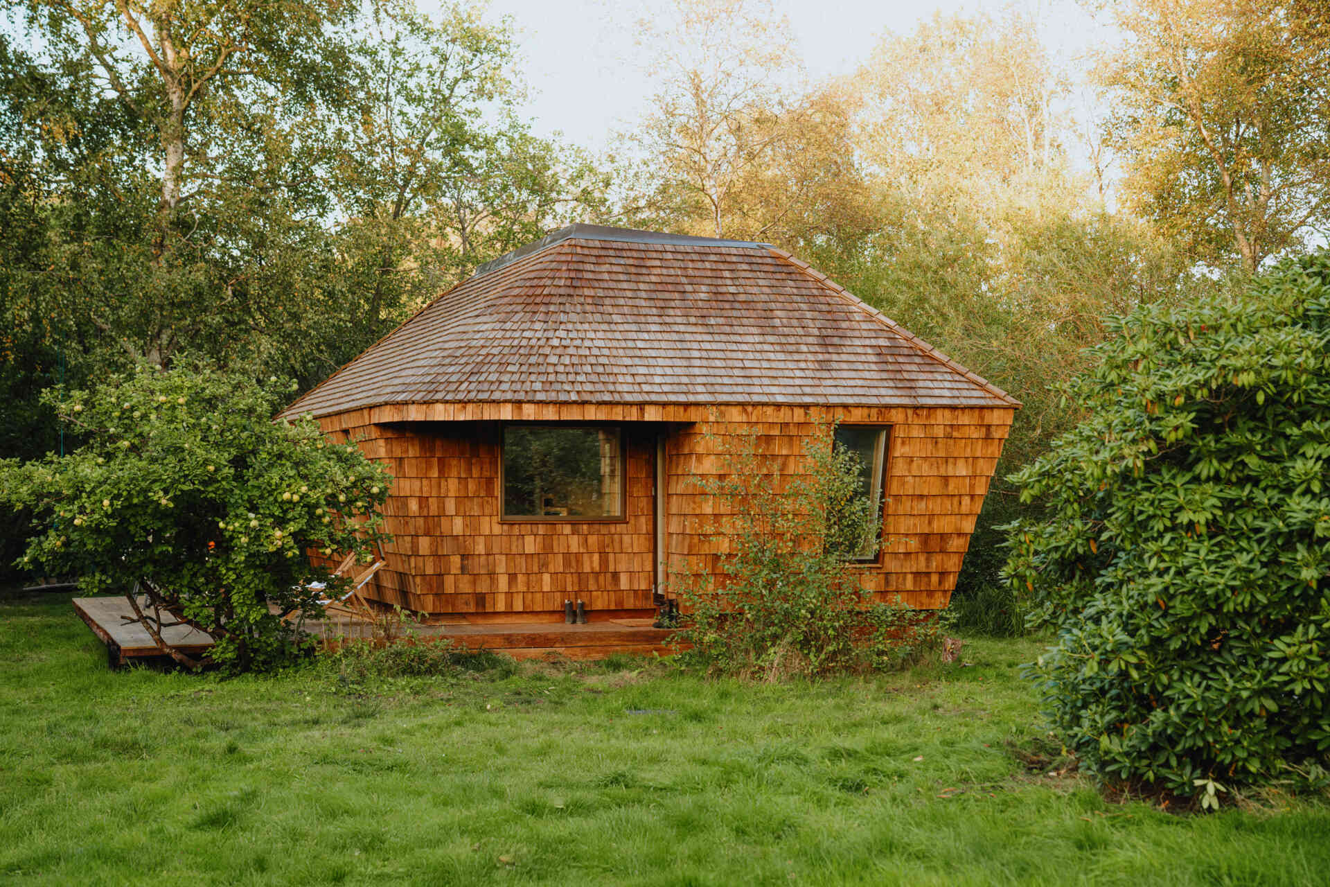 Natural timber, digital fabrication, and a low-carbon approach shape a garden house's warm exterior and efficient construction.