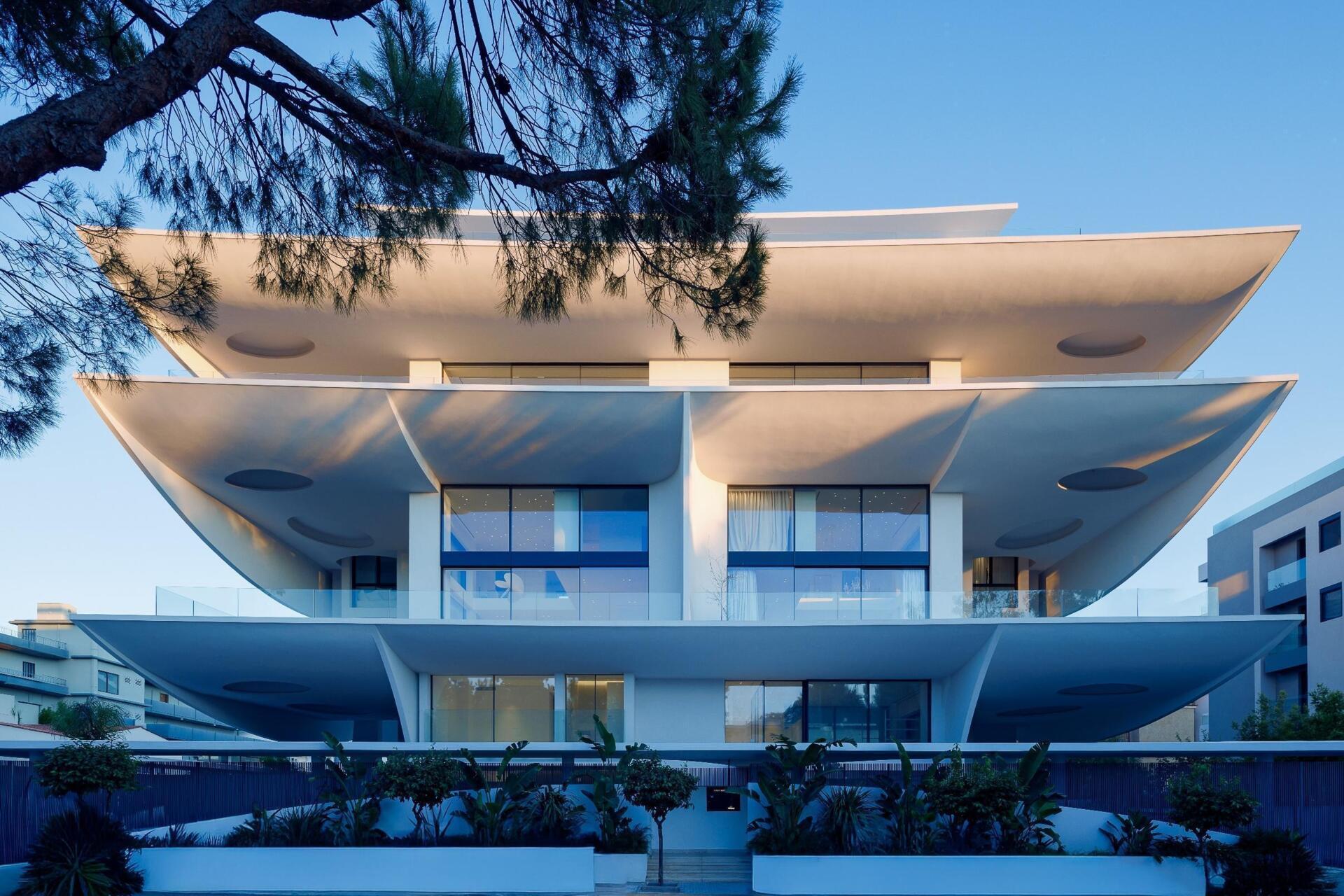 Rêve en suspens by 314 architecture studio brings sculptural architecture to Voula on the Athenian Riviera. Discover how petal-shaped balconies, flowing white forms, and innovative construction combine to create a striking contemporary residential building.