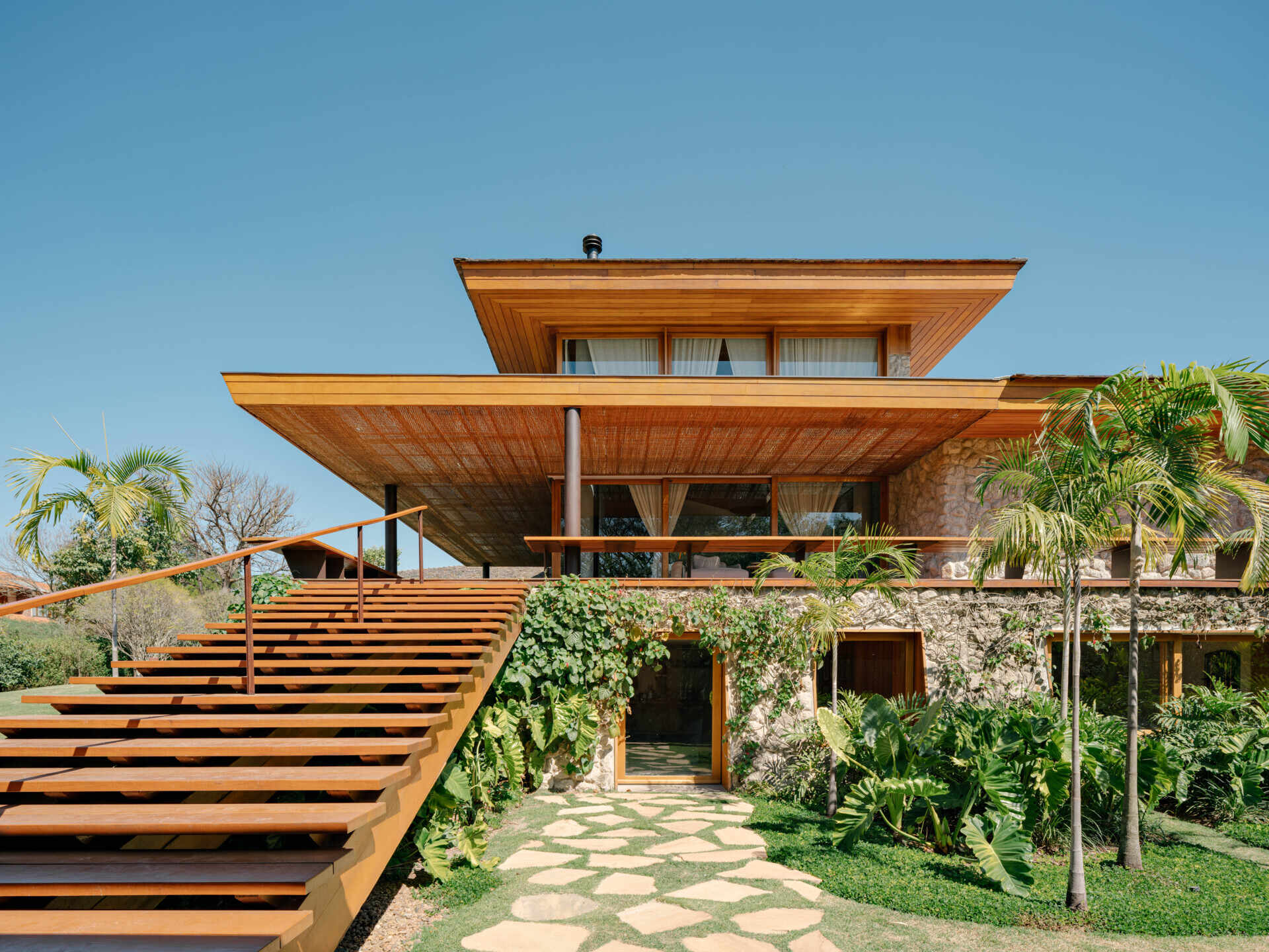 Discover how timber, concrete, basalt and straw combine to give this Brazilian country house its warm contemporary character.