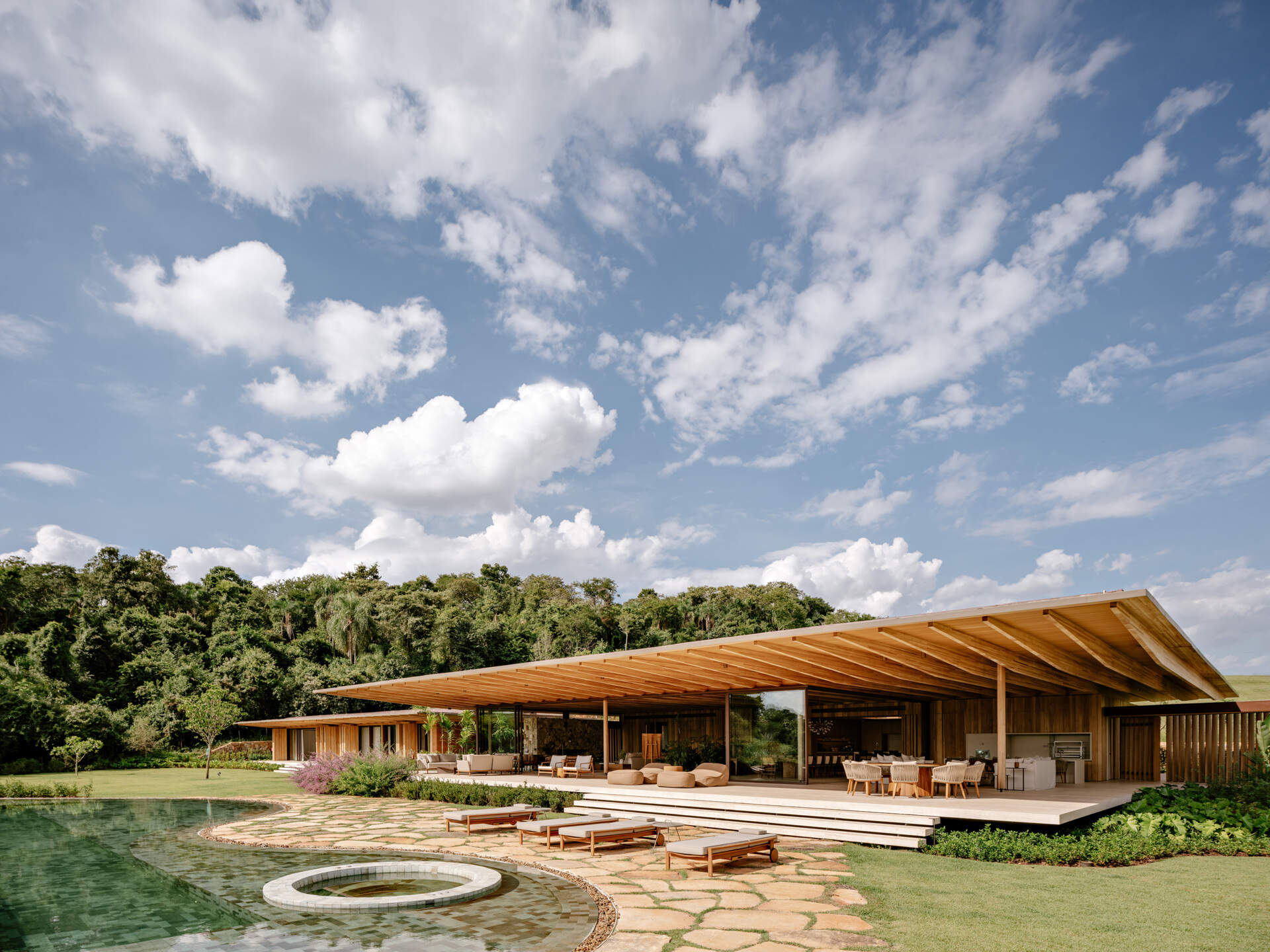 Explore AMS House by Jacobsen Studio, a modern Brazilian home featuring timber architecture, rammed earth walls, and three beautifully connected pavilions.
