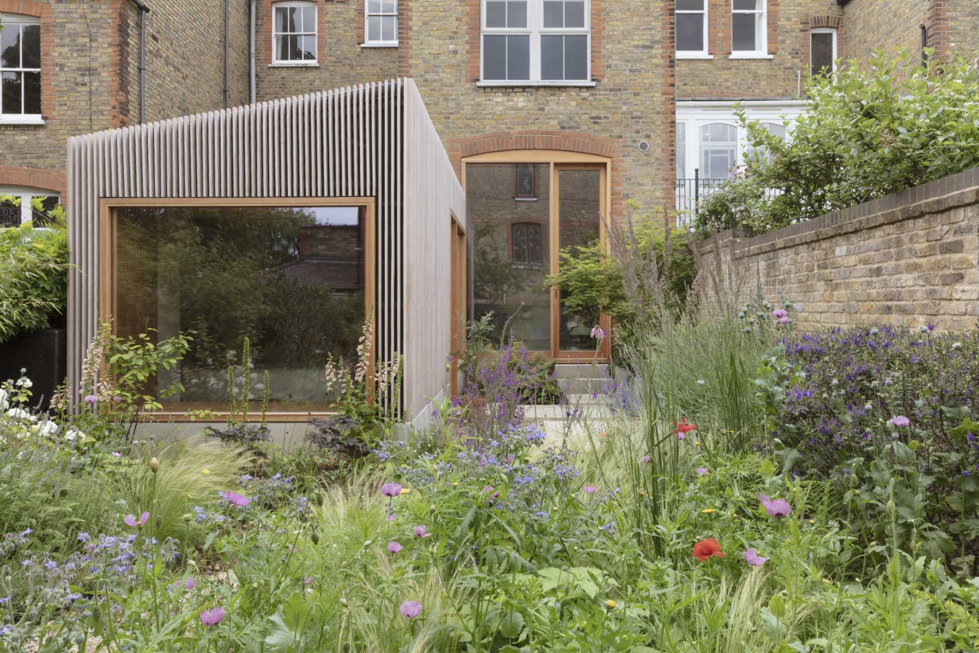 Douglas Fir House by Christian Brailey Architects transforms a neglected London studio into a bright home with a prefabricated timber extension, polished concrete floors, and beautifully crafted interiors.