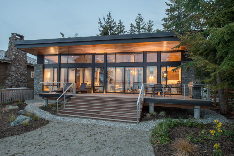 Take a tour of this one-room waterfront studio on Camano Island, where an open floor plan and a double-sided stone fireplace create a clever, space-saving layout.